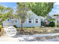 Charming light blue two-story home with landscaped yard, mature trees, and detached garage at 4756 Churchill Rd, North Charleston, SC 29405