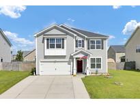 Charming two-story home with gray siding, front lawn, and attached garage at 613 Ravens Wood Rd, Summerville, SC 29486