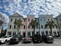 Charming townhomes boast vibrant, pastel exteriors complemented by lush palm trees and convenient parking at 656 Coleman Blvd # 402, Mount Pleasant, SC 29464