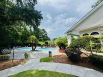 Enjoy the community pool, surrounded by lush landscaping and comfortable lounge chairs at 700 Daniel Ellis Dr # 2203, Charleston, SC 29412