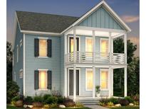 Charming two-story home with a double front porch, light blue siding, black shutters and lush landscaping at 803 Gentle Breeze Dr, Summerville, SC 29486