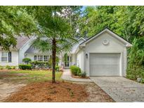 Charming one-story home with an attached garage and beautifully landscaped front yard with a palm tree at 9117 Woodcreek Ct, North Charleston, SC 29406