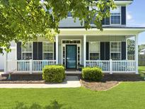 Inviting front porch with white railings and teal chairs, perfect for relaxing outdoors at 1213 Grasswind Dr, Hanahan, SC 29410