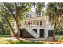 Charming coastal home featuring a welcoming front porch, white railings, and lush landscaping at 2911 Old Tavern Ct, Mount Pleasant, SC 29466