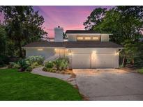 Inviting home exterior with a two-car garage, well-maintained landscaping, and charming curb appeal during twilight at 3 Sand Dollar Dr, Isle of Palms, SC 29451
