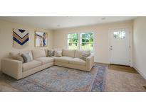 Bright living room features a neutral color palette, plush sectional, and large windows at 526 Branch Bend Way, Cross, SC 29436