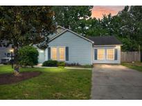 Charming single-story home featuring a well-manicured lawn and inviting curb appeal at dusk at 8108 Halifax Way, North Charleston, SC 29420