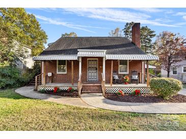 Brick house with front porch, rocking chairs, and landscaped lawn at 3726 The Plaza None, Charlotte, NC 28205