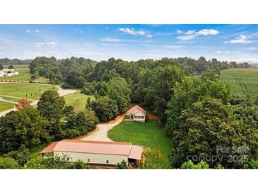 Secluded home nestled among lush trees, boasting a private driveway and a spacious outbuilding at 6051 Pointe West Ln, Vale, NC 28168