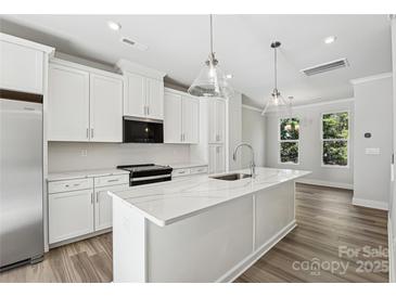 Bright modern kitchen featuring white cabinetry, stainless steel appliances, and a quartz countertop island at 1428 Hamilton St # 13, Charlotte, NC 28206