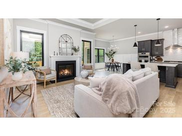 Open living room with fireplace, wood floors, and seamlessly flowing into kitchen and dining areas at 179 Heartland Dr # 8, Rock Hill, SC 29732