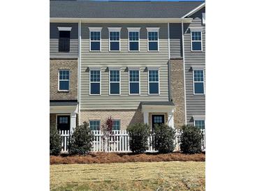 New townhouse with gray siding, brick accents, and a charming white picket fence at 4225 S New Hope Rd # 9, Cramerton, NC 28032