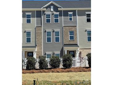 Charming townhome featuring gray siding, brick accents, and manicured landscaping in a friendly neighborhood at 4227 S New Hope Rd # 10, Cramerton, NC 28032