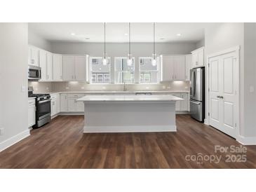 Bright kitchen featuring white cabinets, stainless steel appliances, and a large center island at 417 Prine Pl # Brx0013, Charlotte, NC 28213
