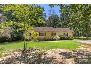 Charming home featuring a well-manicured front yard and mature trees creating a peaceful setting at 1302 Hickory Nut Ln, Lincolnton, NC 28092