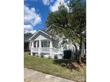 Charming single-story home with a welcoming front porch, white railings, and lovely landscaping at 235 E Moore St, Rock Hill, SC 29730