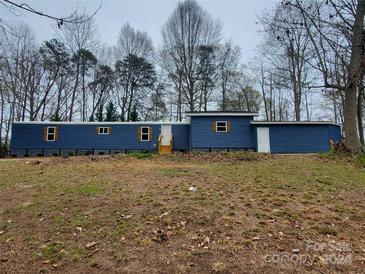 Single-story blue home featuring wood shutters and a gravel yard at 230 Ellen St, Salisbury, NC 28146