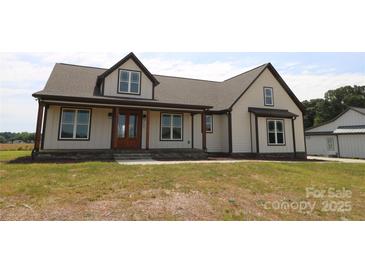 Inviting two-story home featuring a covered front porch, neutral siding, and contrasting dark trim, creating a charming curb appeal at 1405 Coppergate Dr, Salisbury, NC 28147