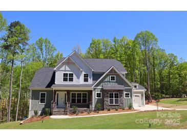 Two-story home featuring stone accents, a covered front porch, and an attached two-car garage at 106 Windbluff Ct # 163, Statesville, NC 28677