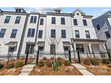 New construction townhomes with a black metal fence and landscaped front yard at 4214 Alexander View Dr # 39, Charlotte, NC 28226