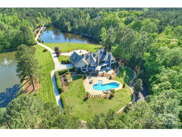 Expansive aerial view of estate with sprawling lawn, private pool, and serene lake featuring fountains at 525 Lake Lynn Rd, Concord, NC 28025