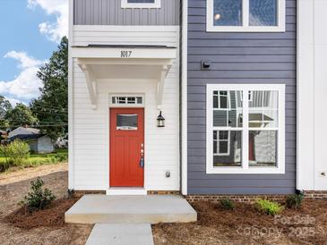 Two-story townhome with gray and white siding, red front door, and landscaping at 2125 Acclaim St, Charlotte, NC 28205