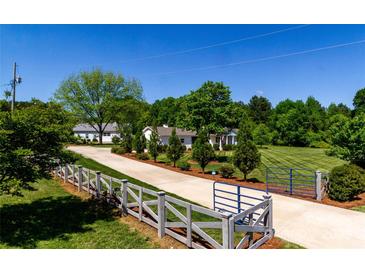 Beautiful home showcasing manicured landscaping and a gated driveway leading to the residence at 796 Cornelius Rd, Mooresville, NC 28117