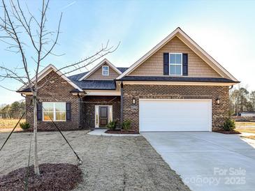 Charming brick home featuring a two-car garage, well-manicured lawn, and inviting front entrance at 1108 Piper Meadows Dr # 52, Waxhaw, NC 28173