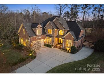 Stunning two-story brick home boasts a large driveway and manicured landscaping with accent lighting at 2012 Tomshire Dr, Gastonia, NC 28056