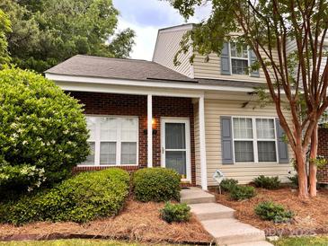Charming two-story townhome featuring brick accents and a well-maintained front yard at 10875 Holly Ridge Blvd, Charlotte, NC 28216