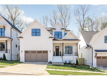 Charming two-story home featuring a modern design, white siding, and a two-car garage with attractive landscaping at 3945 Plainview Rd, Charlotte, NC 28208