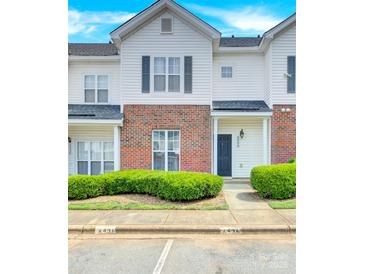 Two story brick and white townhome with landscaping and parking at 6436 Mallard View Ln, Charlotte, NC 28269