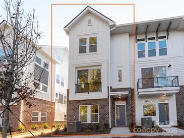 Charming three-story townhome featuring a brick base, neutral siding, and large windows at 1413 Collier Walk Aly # Csw0106, Charlotte, NC 28205