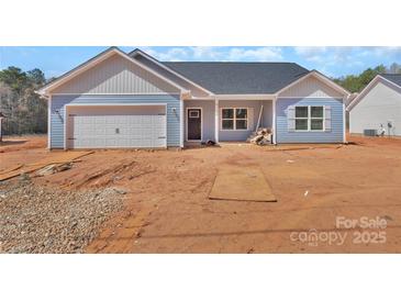 Charming single-story home with blue siding, garage, and covered front entry showcasing a modern, cozy design at 6160 Lowder Rd, Salisbury, NC 28147