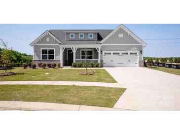 Charming craftsman-style home with a manicured lawn and welcoming front porch at 4679 Hopsack Dr # Cal0108, Indian Trail, NC 28079