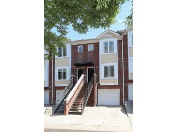 Brick townhome with white trim, attached garages, and shared staircase leading to front doors at 1125 Kurt Ct, Charlotte, NC 28209