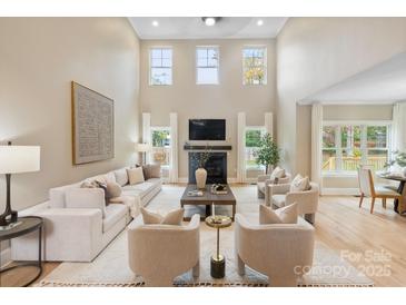 Bright living room features a fireplace, tall windows, and neutral furniture at 4023 Randolph Rd, Charlotte, NC 28211