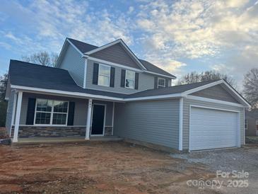 Charming two-story home with gray siding, stone accents, and a two-car garage at 805 W Main St, Marshville, NC 28103