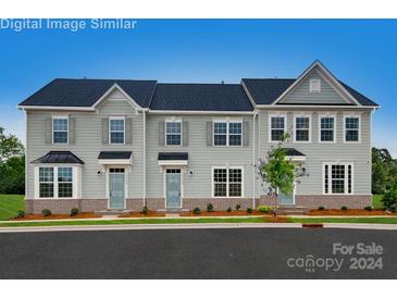 Attractive townhome featuring light gray siding, dark roof, and a neatly landscaped front yard at 420 Serenity Cir, Cramerton, NC 28032