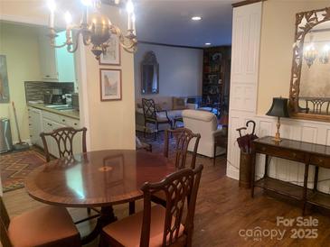 Elegant dining area with hardwood floors and a charming chandelier at 1323 Queens Rd # 212, Charlotte, NC 28207