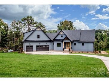 Charming two-story home featuring a well-manicured lawn and three-car garage at 116 Emmaline Ct, Troutman, NC 28166