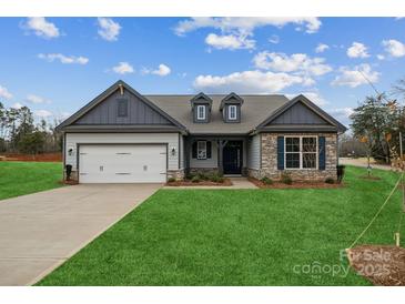 Charming single-Gathering home with stone accents, a well-manicured lawn, and inviting curb appeal at 104 Brooke Forest Ct, Mooresville, NC 28115