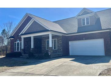 Charming brick and stone home featuring a two-car garage and covered front porch at 1302 Devonmere Pl, Salisbury, NC 28144