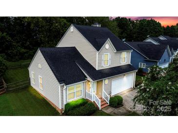 Two-story house with a beige exterior, black roof, and a well-manicured lawn at 4816 Windchase Ln, Charlotte, NC 28269