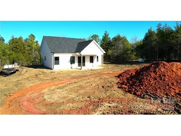 Newly constructed home with a white exterior, dark roof, and covered porch at - Beltline Rd # 10, Chester, SC 29706