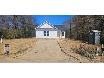 Charming single-story home with white siding, a black roof, and visible construction progress in the front yard at 1011 Indiana St, Kannapolis, NC 28083
