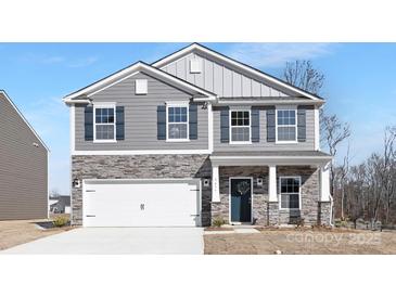 Charming two-story home showcasing stone accents, gray siding, and a welcoming entrance at 3655 Mercer St, Terrell, NC 28682