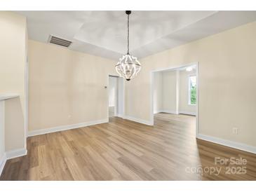 Bright dining room features hardwood floors and a modern chandelier at 9031 Rosalyn Glen Rd, Cornelius, NC 28031