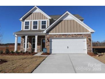 Two-story home featuring a two-car garage, stone accents, vertical siding, and a well-manicured front lawn at 2054 Van Buren Rd, Sherrills Ford, NC 28673