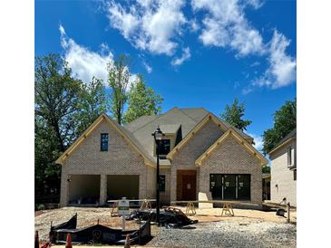 Charming new construction home featuring a gray brick facade, two-car garage, and a well-manicured lawn at 1211 Royal Prince Ct, Charlotte, NC 28211